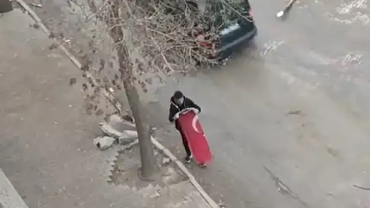 Yerdeki Türk bayrağını önce kaldırıp öptü, ardından yıkayıp balkona astı